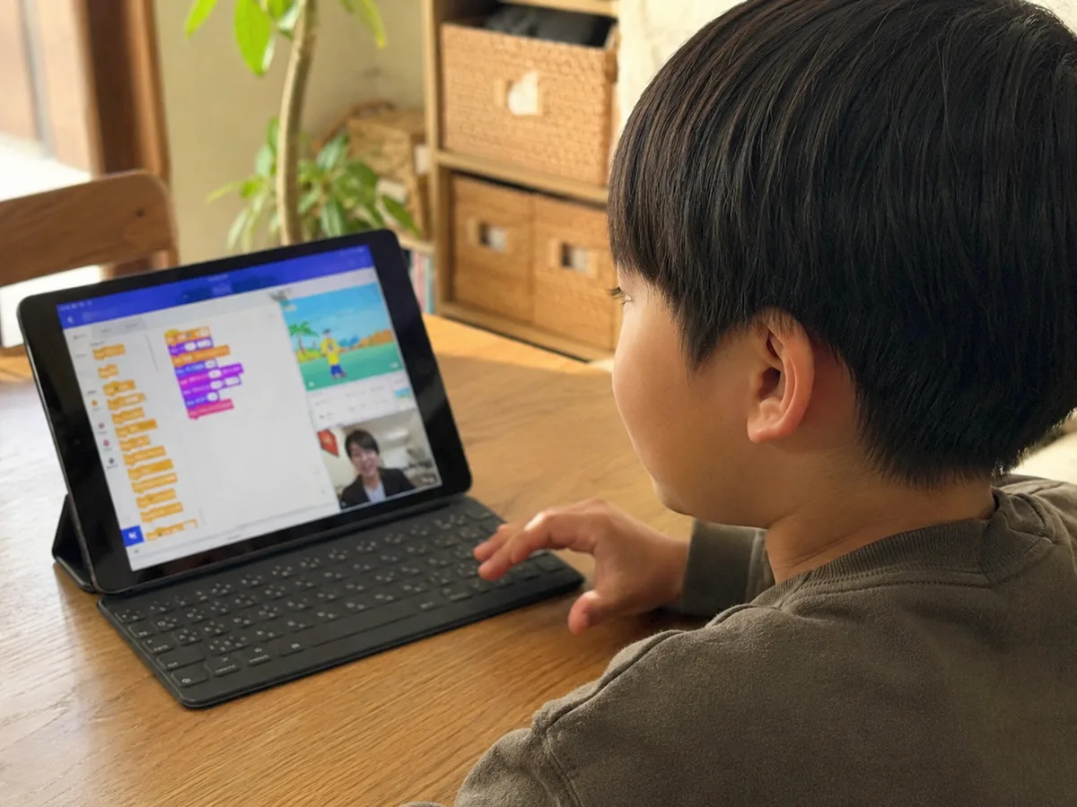 小学生がタブレットでScratchのオンラインレッスンを受けている様子